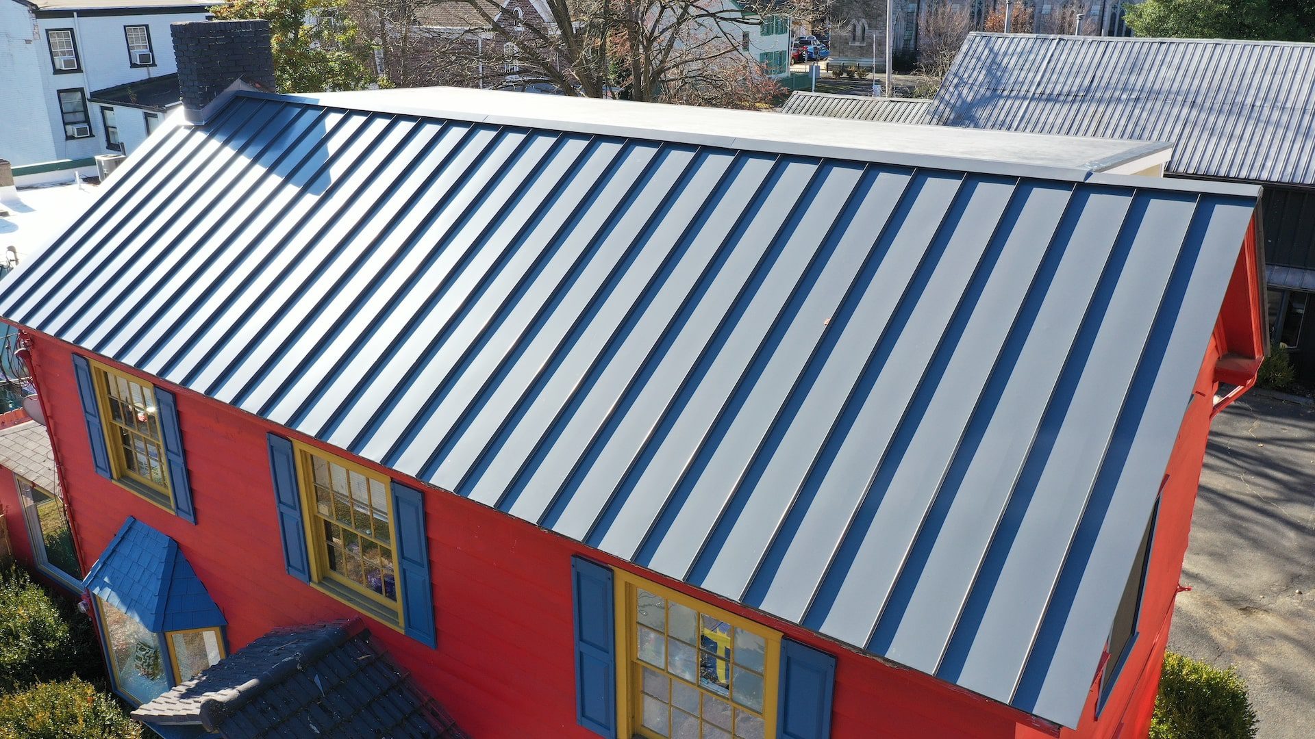 Lambertville Metal Roof-side-1-min Image of a bright red building with blue metal roof installed by Alte Exteriors.