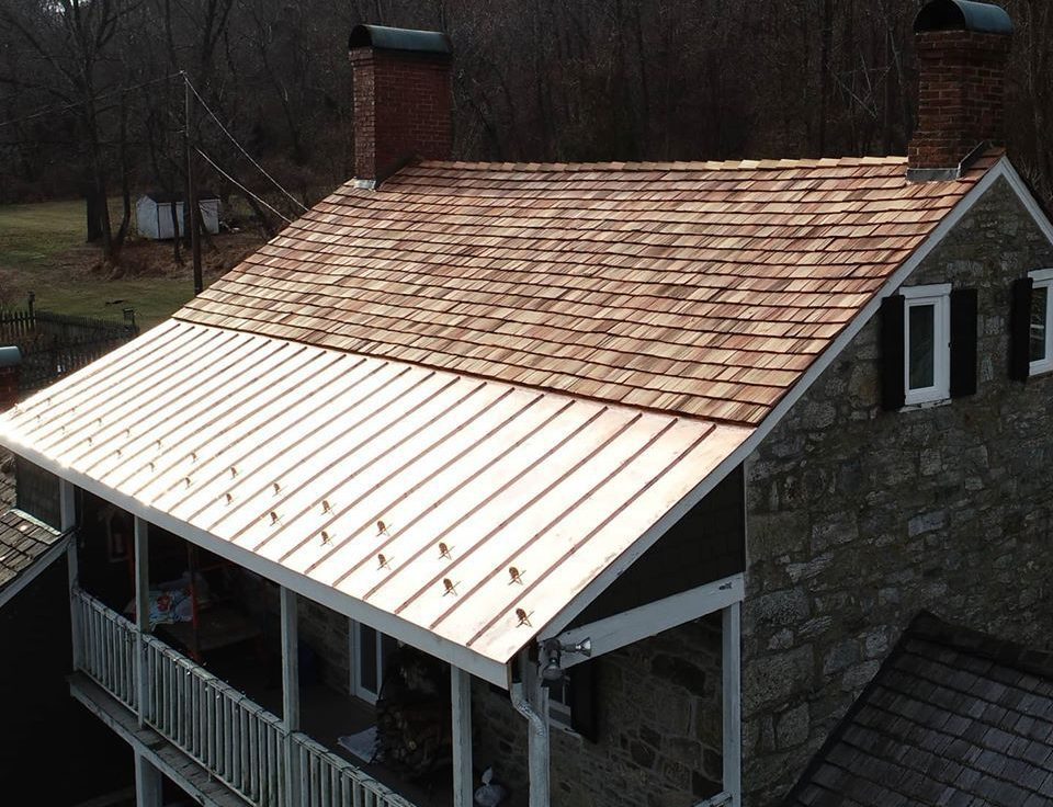 Image of a roof installed with both copper and cedar shake shingles - by  copper roofing contractor Alte Exteriors